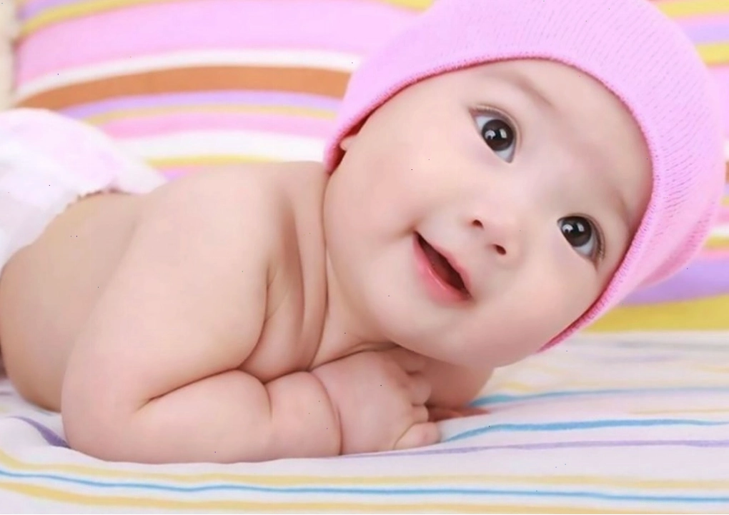 Bé trai đang cầm bình sữa, vẻ mặt đòi uống