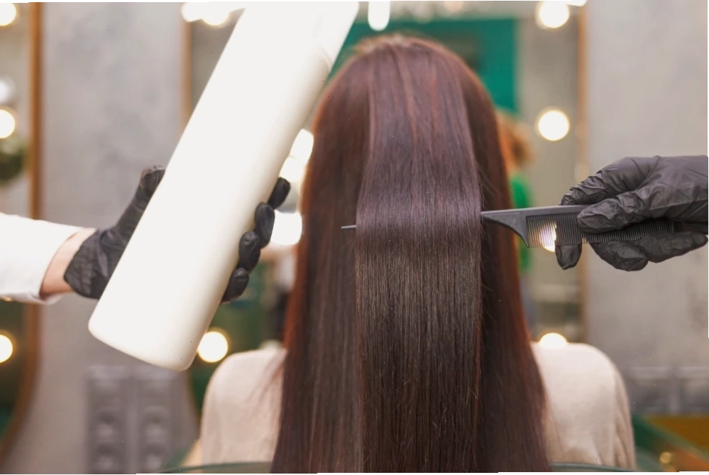 Chuyên viên salon đang thực hiện liệu pháp keratin hair treatment cho khách hàng
