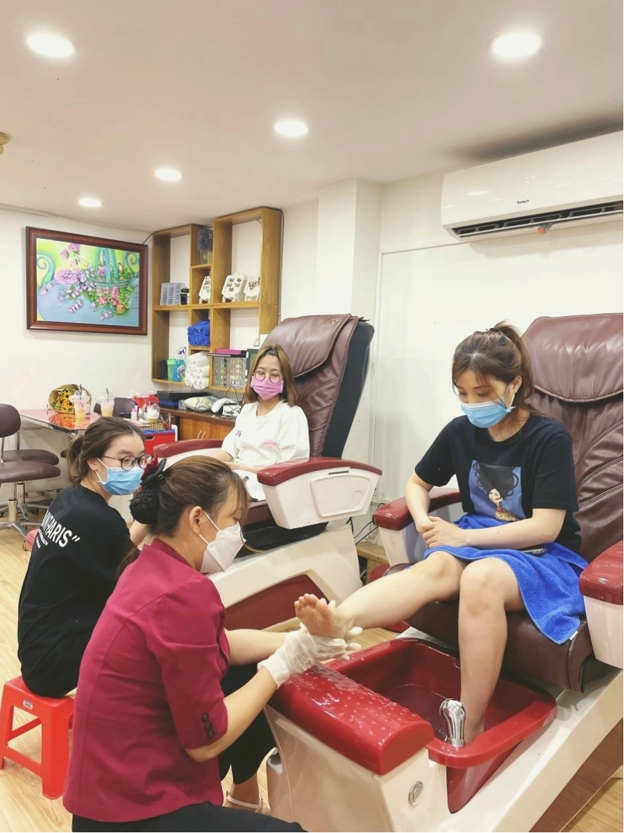 Người thợ nail đang thực hiện kỹ thuật vẽ trên móng